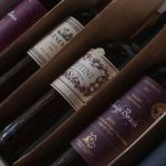 Caixa com diversas garrafas de vinhos argentinos de diferentes rótulos e safras.