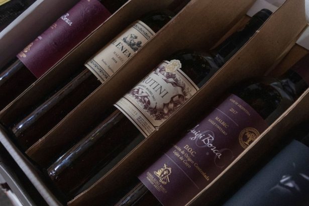Caixa com diversas garrafas de vinhos argentinos de diferentes rótulos e safras.