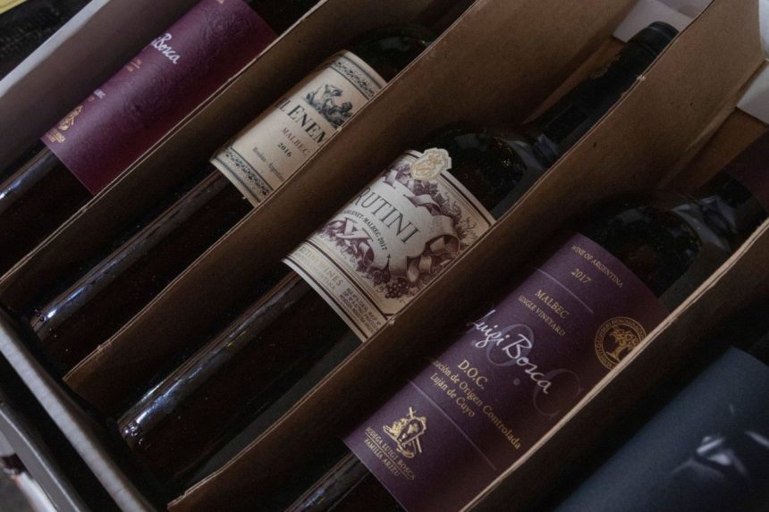 Caixa com diversas garrafas de vinhos argentinos de diferentes rótulos e safras.